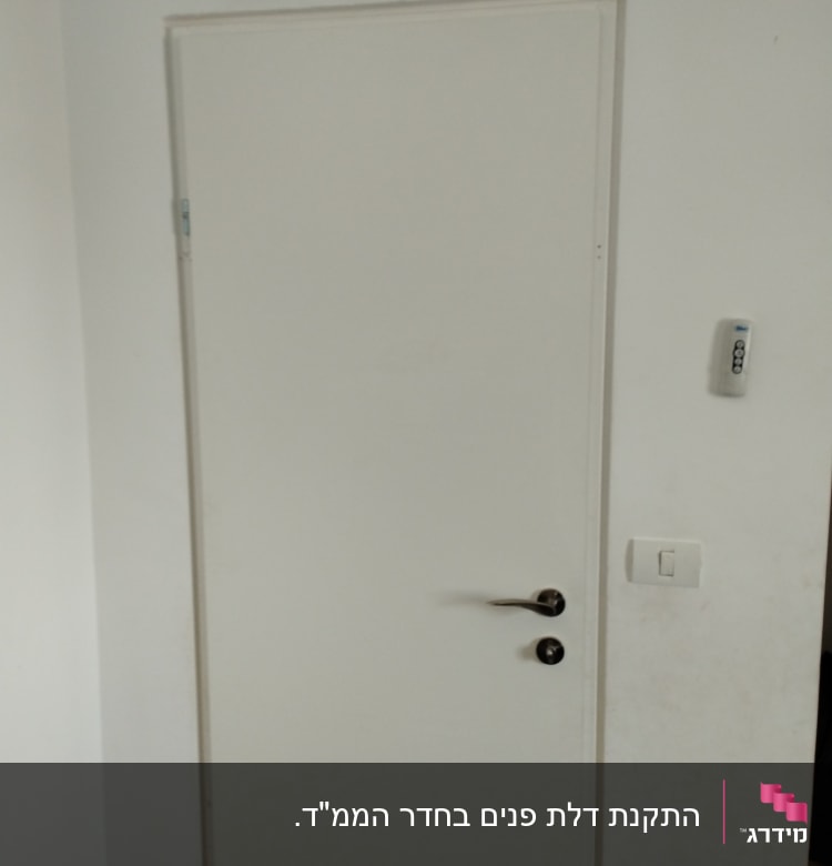 דלת לבנה עם ידית מתכתית ומתג ליד